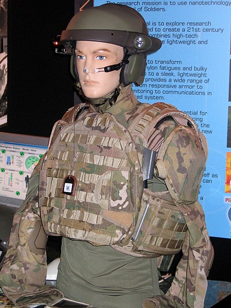 یک مانکن در نمایشگاه دستاورد های نظامی در امریکا در سال 2004 نمونه اولیه از لباس های combat shirt و جلیقه ای با طرح استتار MultiCam را به نمایش گذاشته است